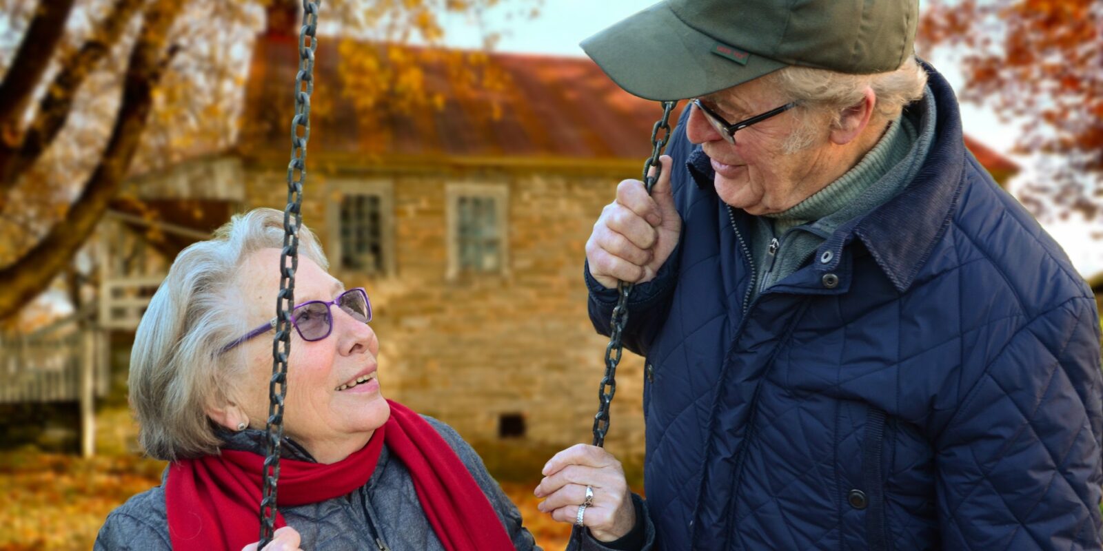 An elderly couple in winter jackets looking at each other