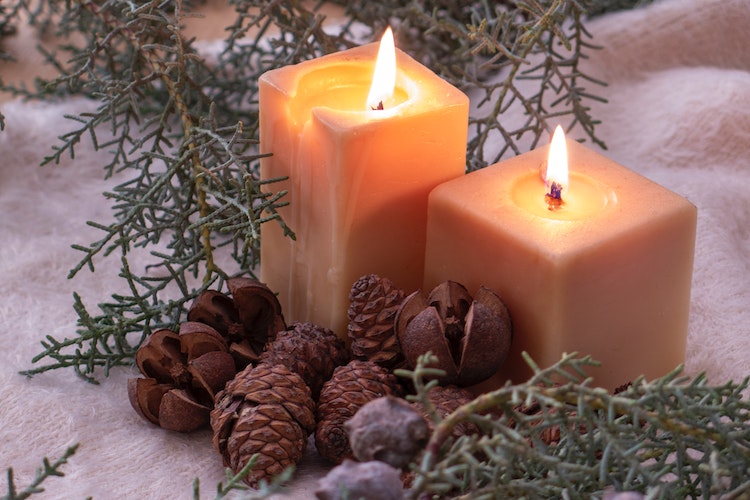 Two candles and some small pinecones