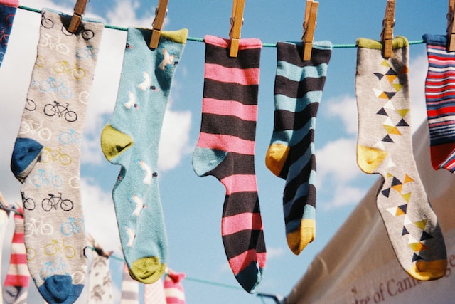 Colorful socks drying on a wire.