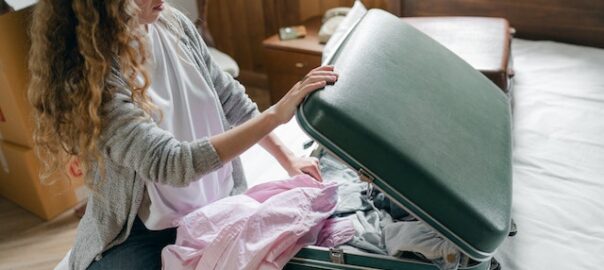 Woman packing a suitcase on a bed