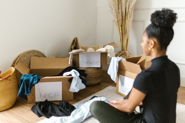 Woman sorting out her belongings to make her home feel less cramped.