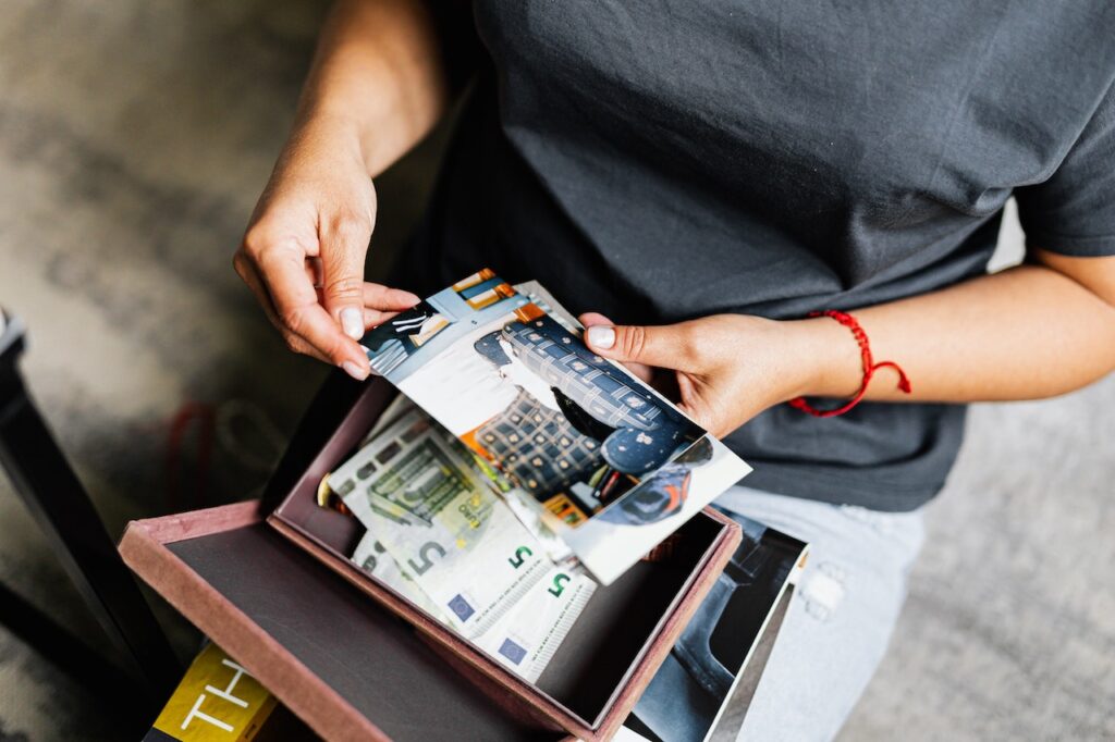 During a move, a woman looks through a box with photos and other sentimental items.