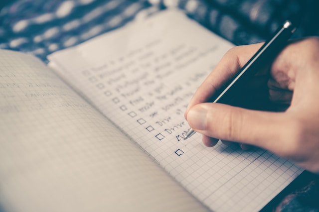 A person making a checklist, which is very useful when moving on your own.