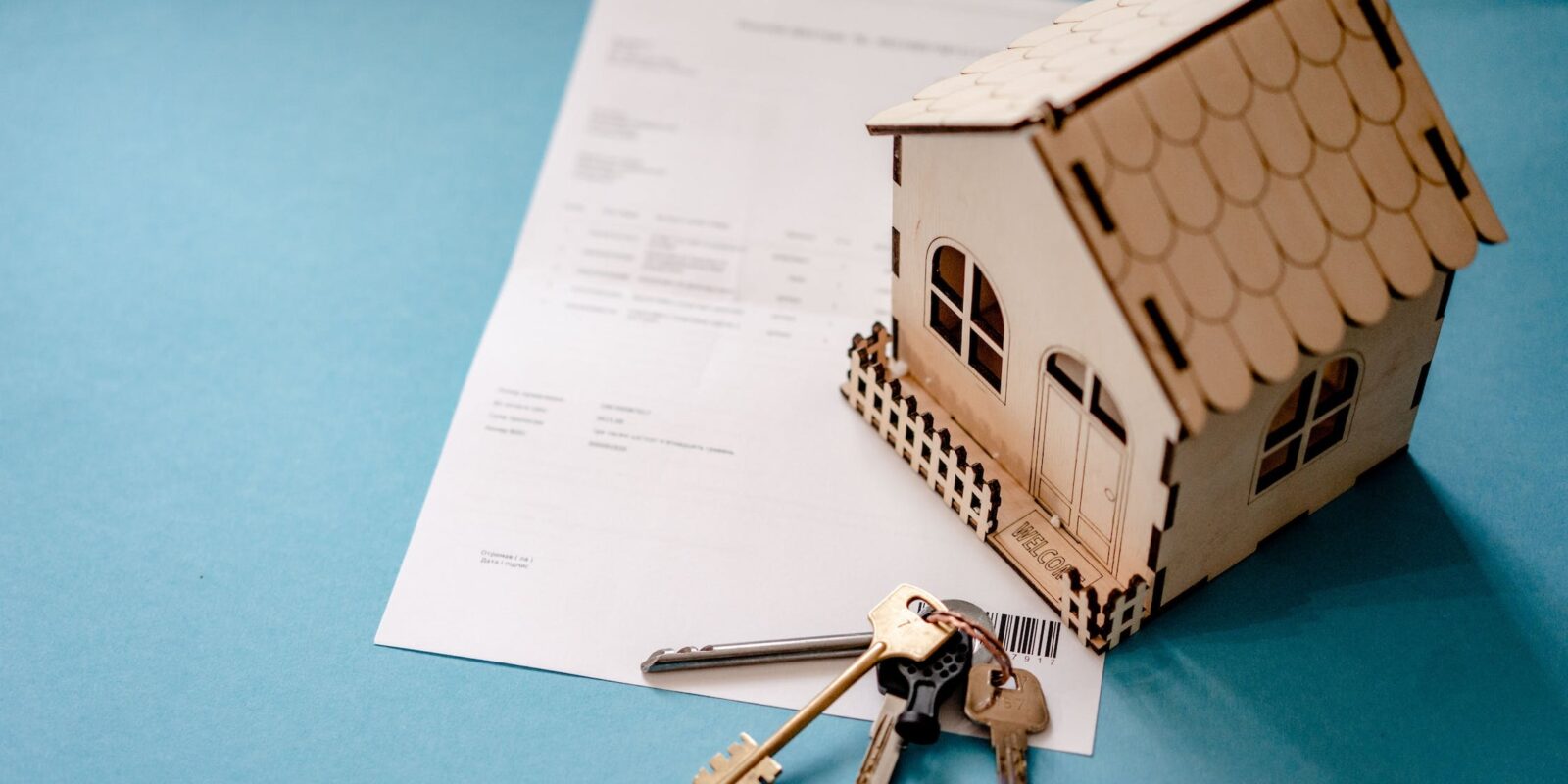 A miniature house and keys over a contract, symbolising the need for negotiation strategies for securing the ideal lease