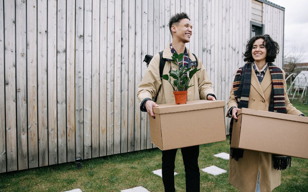 A couple holding boxes when moving back home after living abroad