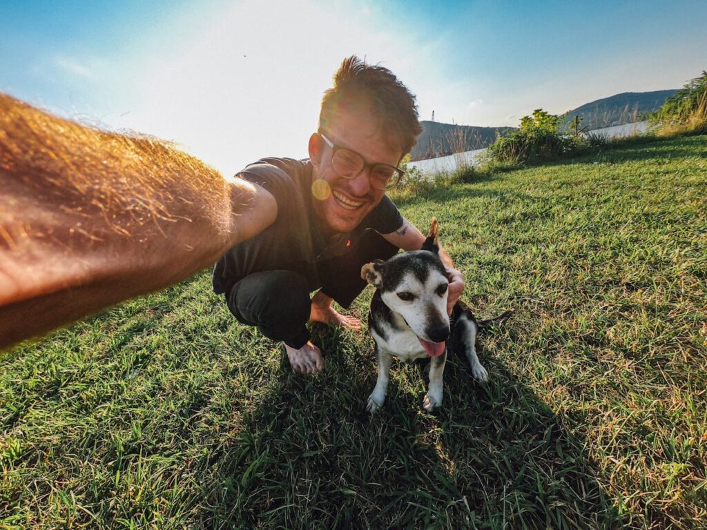 A man taking a selfie with his dog in the outdoors